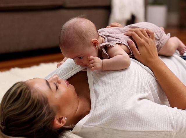 Baby doing tummy time on their mother's chest